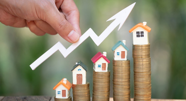 Coins with small houses on top displaying an upward growth financial chart
